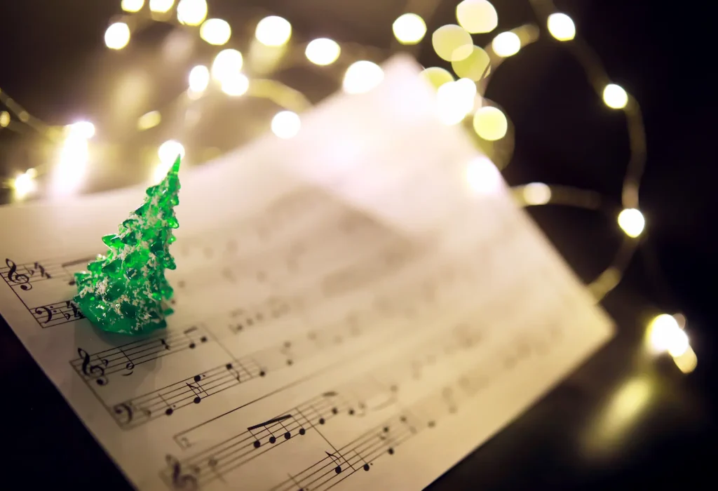 old-sheet-with-christmas-music-notes-as-background-against-blurred-lights-christmas-music-concept